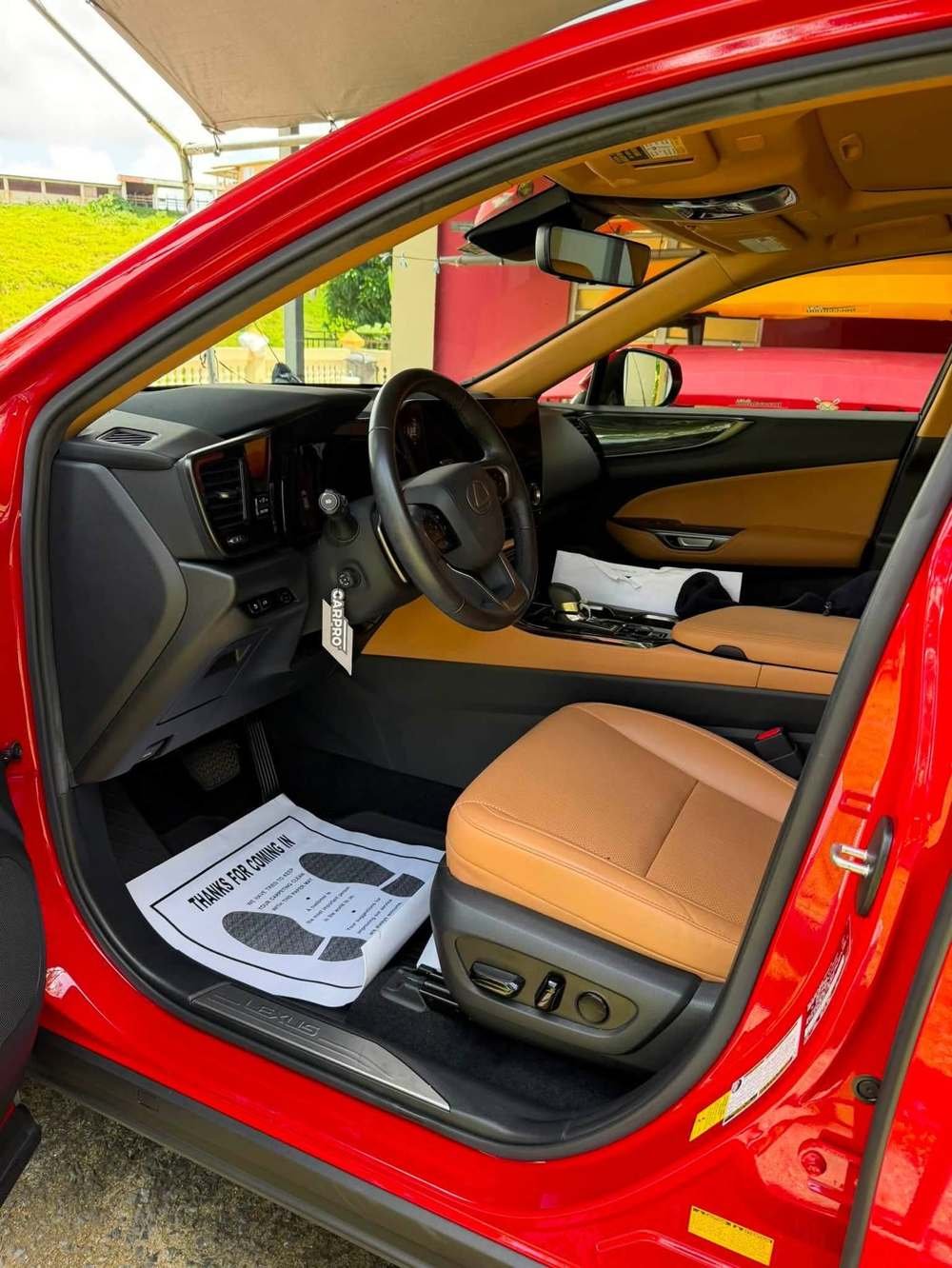 Interior de Lexus con puerta abierta y tapete de cortesía