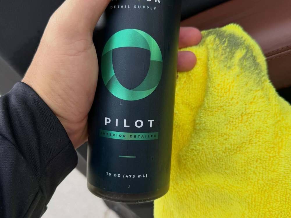 Botella de Armour Pilot interior detailer con toalla amarilla